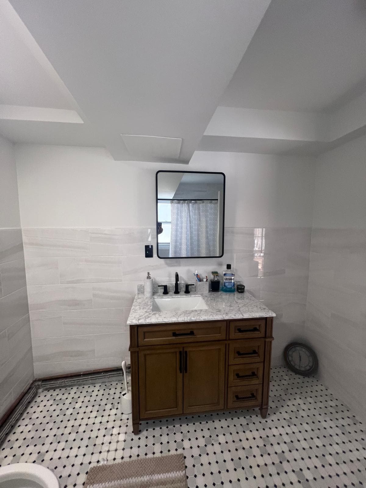 Amoah's Bathroom Renovation — Finished vanity with walnut cabinet, marble top, black faucet, and framed mirror