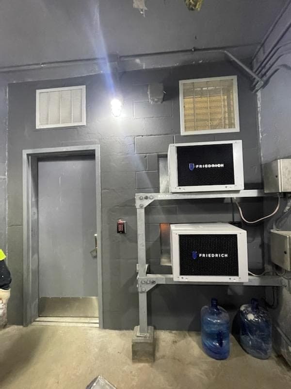 MTA Contract C-43069 — Communication Room Upgrade — Completed communication-room exterior with new through-wall Friedrich AC units, refreshed door, and painted CMU walls